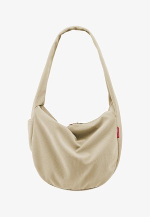 Beige Cord-Taschen mit breitem Riemen und Reißverschluss, mit einem kleinen roten Markenlabel an der Seite.