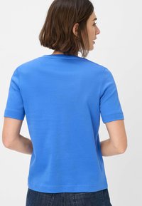T-shirt blu a maniche corte realizzato in cotone morbido, con un classico scollo rotondo e un design semplice senza stampe o decorazioni.