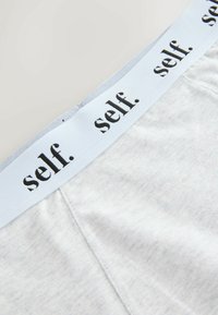 Heledad hall koos pehme vöökohaga, millel on musta värvi tekst "ise." Prinditud. Sile tekstuur ja mugav istuvus.