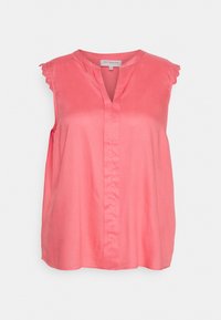 Koraliowa bluzka bez rękawów z gładkiego materiału, z dekoltem w kształcie litery V i delikatnym koronkowym wykończeniem na krawędziach ramion. Detal pionowej szwy na środku.
