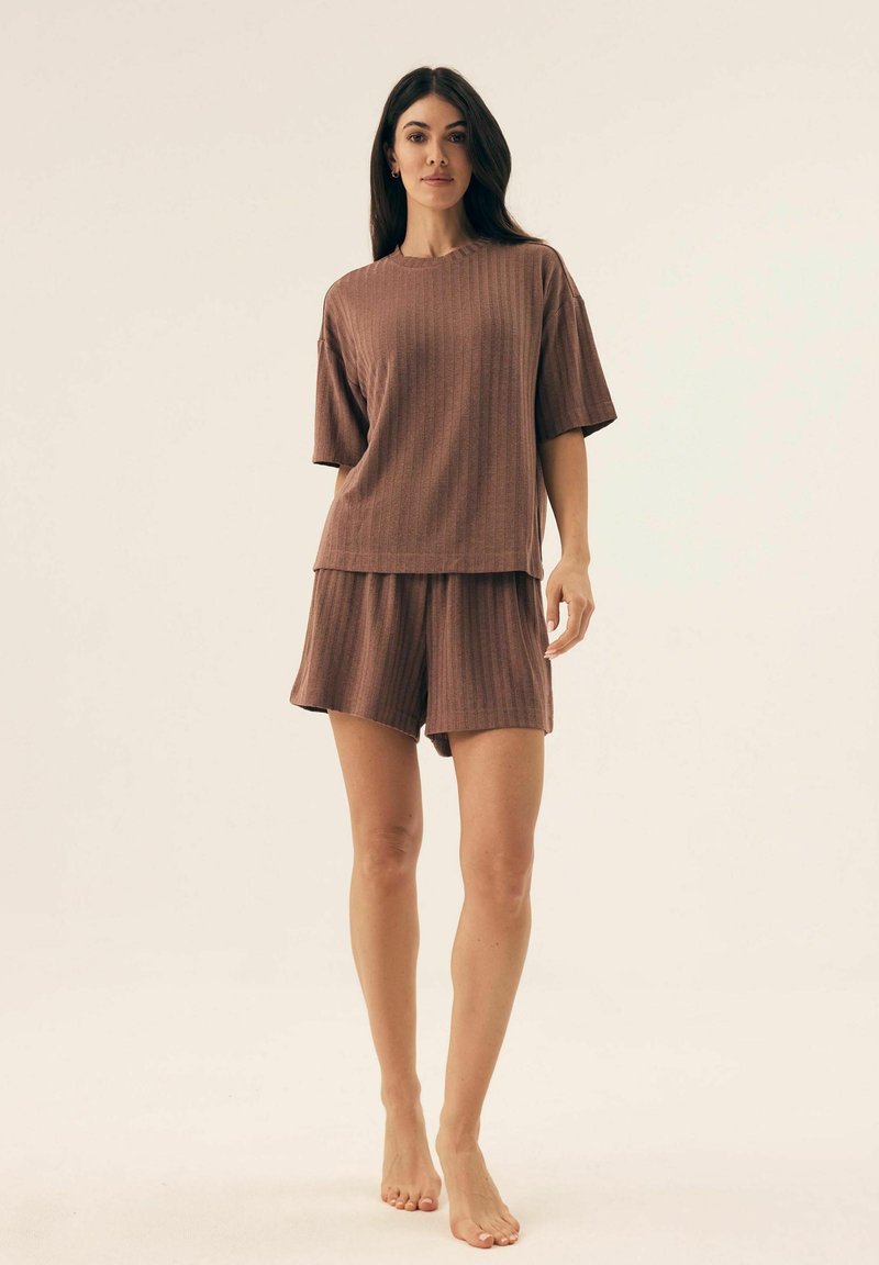 Brązowy zestaw do lounge z prążkowanym wzorem, składający się z koszulki z krótkim rękawem i szortów z wysokim stanem. Miękka tekstura, luźny krój i skromna długość.
