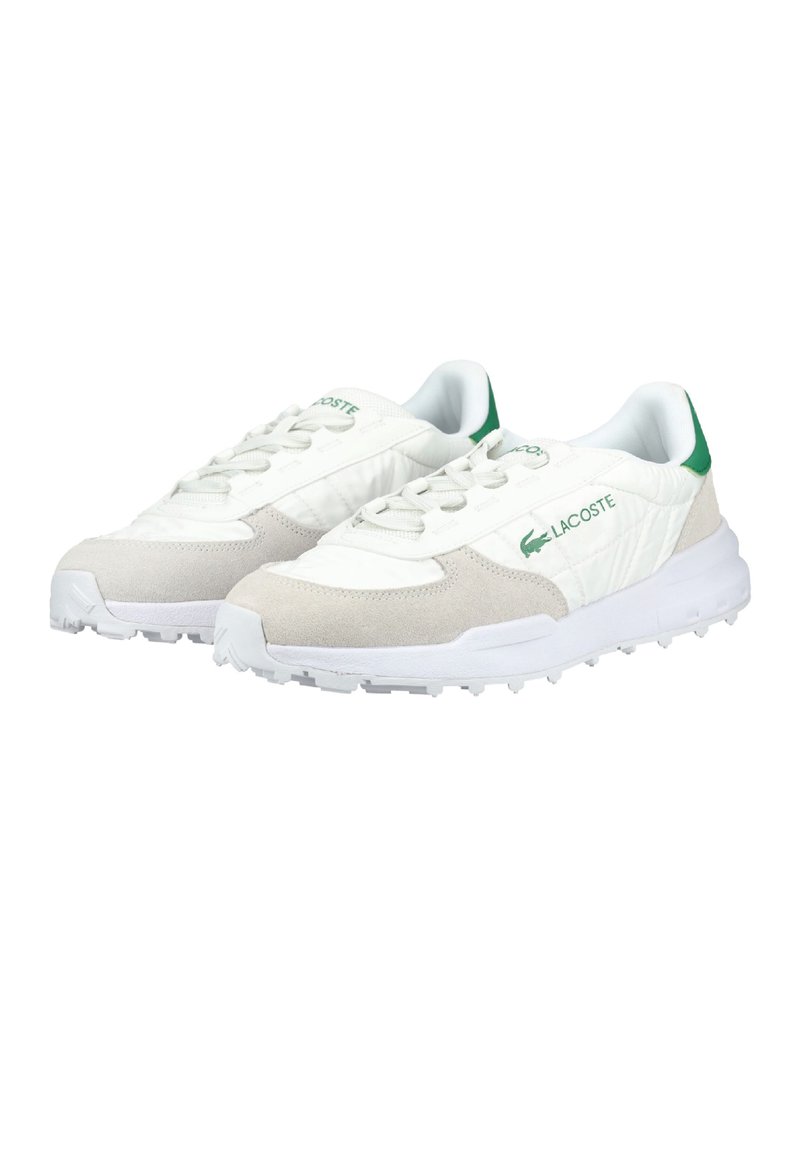 Coppia di sneakers Lacoste bianche e beige con logo verde e contrafforte sul tallone, caratterizzate da suole testurizzate e chiusura con lacci.