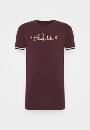 Bordowy t-shirt z krótkim rękawem, z białym i złotym logo "SikSilk" na piersi oraz białymi prążkowanymi mankietami na rękawach.