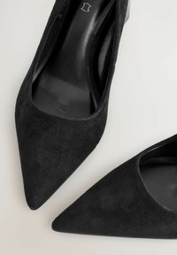 Mustat mokka korkokengät, joissa on terävä kärki ja sileä vuori. Erottuva elegantti muoto ja tekstuuri.