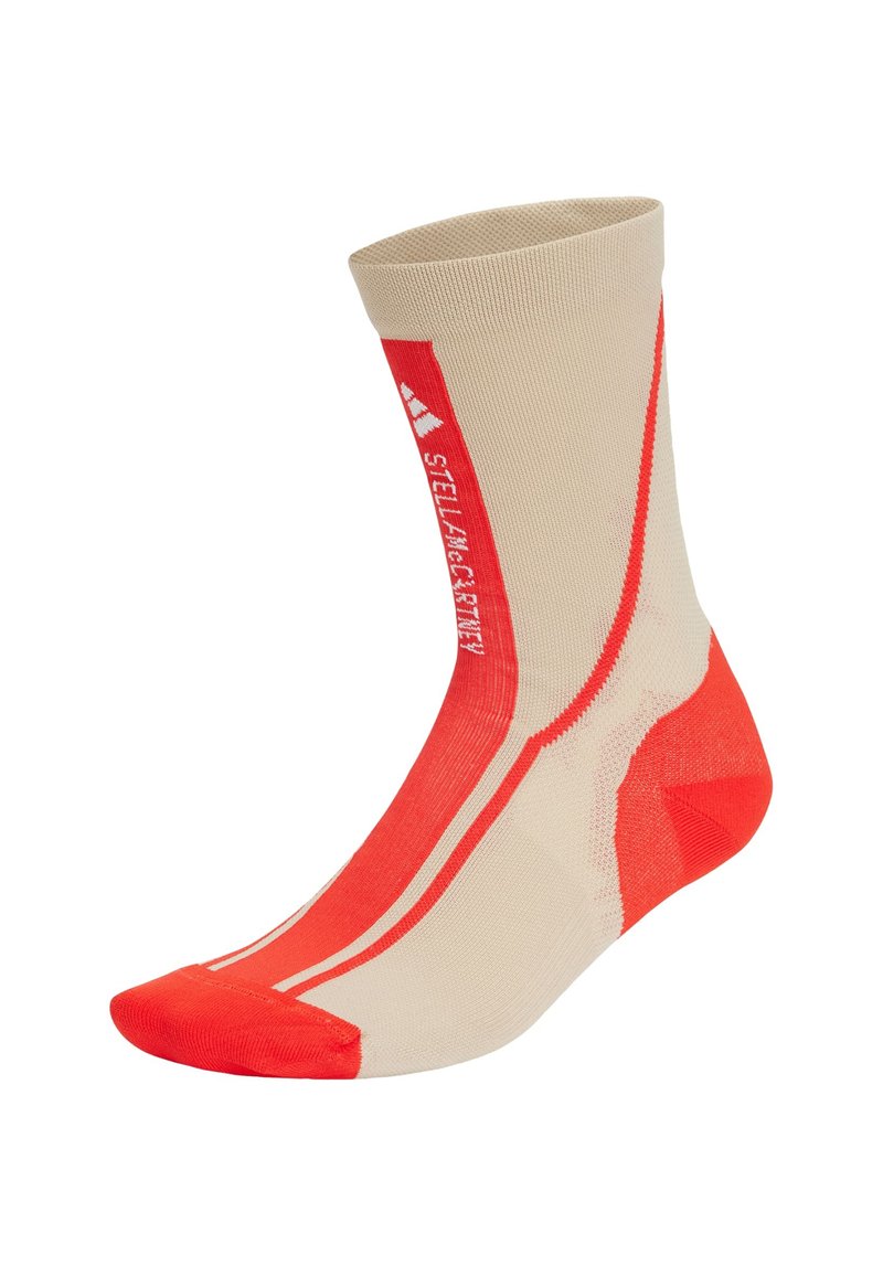 Calcetín deportivo marrón y rojo con parte superior acanalada, talón y puntera reforzados, y rayas diagonales; hecho de material flexible y texturizado para mayor comodidad.