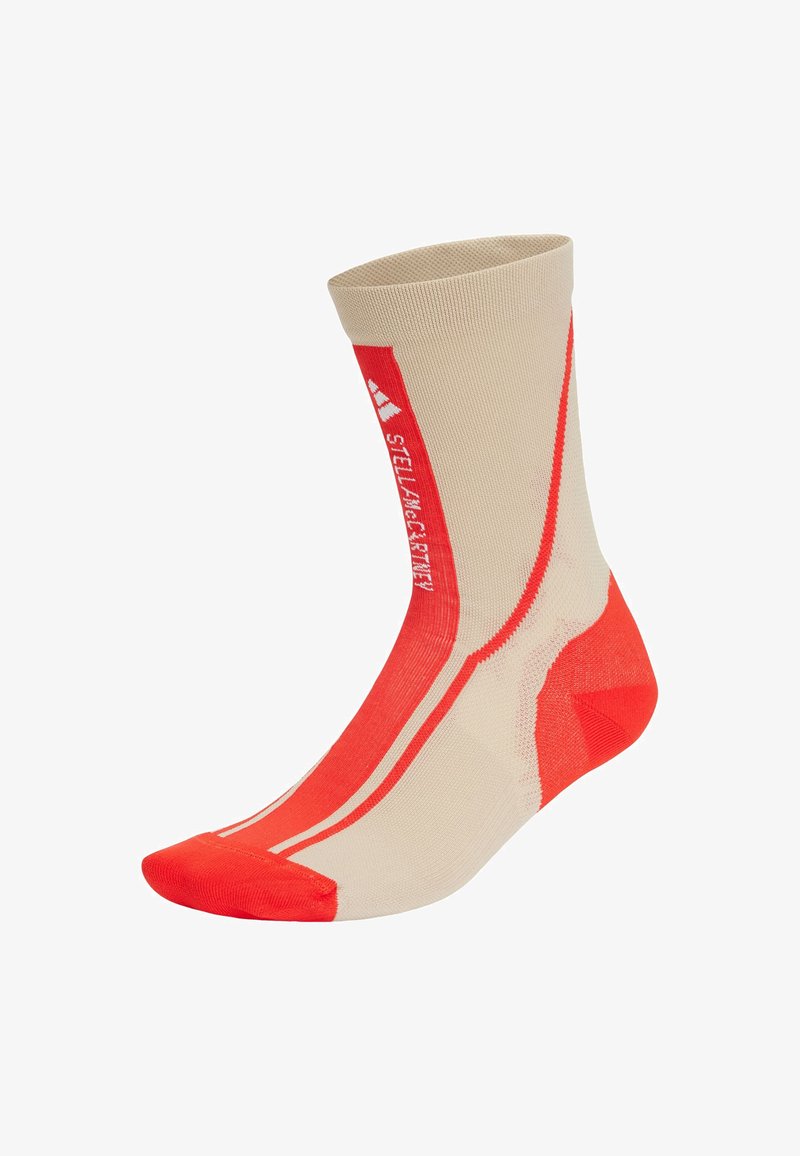 Calcetín deportivo marrón y rojo con parte superior acanalada, talón y puntera reforzados, y rayas diagonales; hecho de material flexible y texturizado para mayor comodidad.