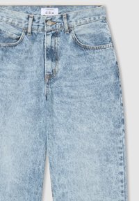 Jeans in denim blu chiaro con finitura sbiadita, dotati di cinque tasche, cuciture a contrasto e chiusura frontale con bottone standard.