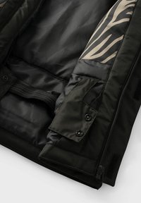 Schwarze Steppjacke innen, mit einer glatten, matten Textur. Ein Ärmel hat einen akzentuierten braunen Zebramuster. Die Verschlüsse bestehen aus Knöpfen und einem Reißverschluss.