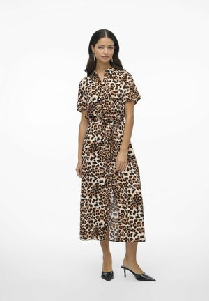Robe en imprimé léopard en tissu léger avec un col, des manches courtes, une taille à nouer et une silhouette longue et fluide. Talons aiguilles noirs.
