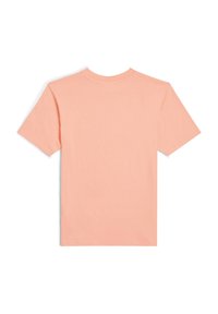 Camiseta de manga corta en melocotón pastel con cuello redondo, que presenta una textura suave y sin patrones o diseños visibles. Silueta limpia y simple.