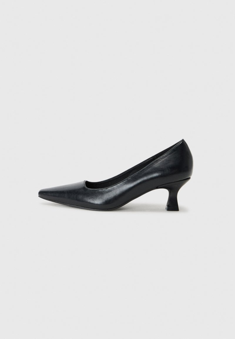 Zapato de tacón negro de cuero con punta afilada y tacón bajo tipo bloque. Textura suave, líneas limpias, diseño sencillo sin patrones ni adornos visibles.