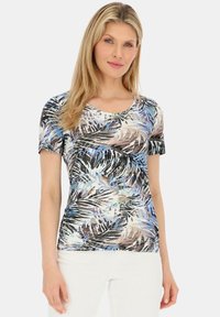 Koszulka z krótkim rękawem, dopasowana, z tropikalnym nadrukiem liści w odcieniach niebieskiego, czarnego i brązowego na jasnym tle. Gładka tekstura materiału.