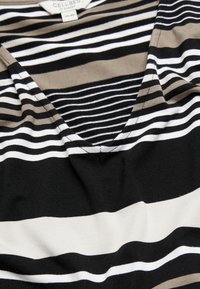 Gestreifter Stoff in Schwarz, Weiß und Beige mit V-Ausschnitt-Design. Weicher, dehnbarer Stoff. Verfügt über unterschiedlich breite Streifen.