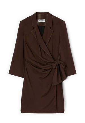 Donkerbruine wikkeljurk met driekwart mouwen, reverskraag met inkeping en strikdetail aan de zijkant, plat neerlegd op een witte achtergrond.