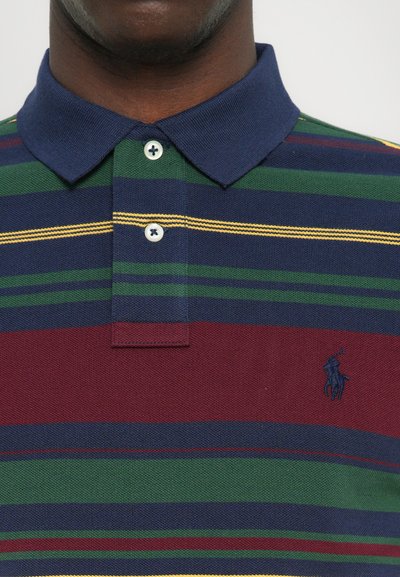 Tricou polo cu guler bleumarin, având dungi orizontale în verde, vișiniu și albastru. Include două nasturi și detalii brodate cu logo.
