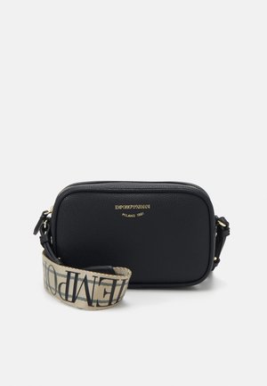 Čierna kožená crossbody taška so zlatým logom, zipsom a vzorovaným textilným popruhom s kontrastným textom. Obdĺžnikový tvar, textúrovaný povrch.