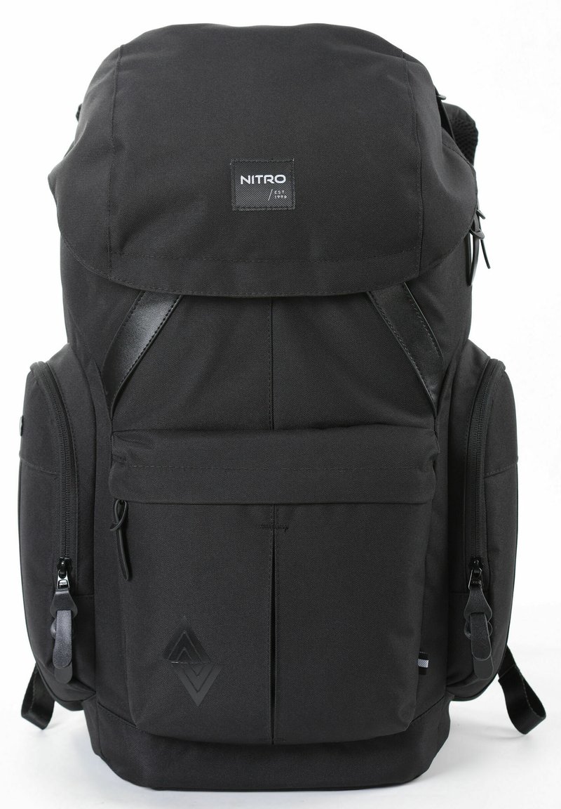 Schwarzer Stoff-Rucksack mit einer oberen Klappe, verstellbaren Trägern, mehreren Reißverschlussfächern und einem strukturierten Logo-Detail auf der Vorderseite.