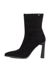 Stivale alla caviglia in suede nero con punta affilata, tacco alto a blocco e un piccolo logo rotondo vicino al bordo superiore sul lato esterno.