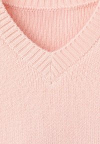 Maglione lavorato a maglia rosa chiaro con colletto a V a coste, che mostra una dettagliata trama e pattern dei punti.