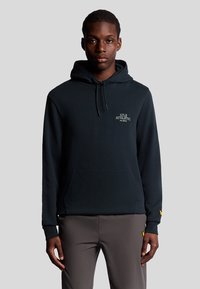 Felpa con cappuccio di cotone blu scuro, con tasca frontale e cappuccio regolabile. Logo in piccolo testo bianco sul petto, con dettagli gialli sulle maniche.