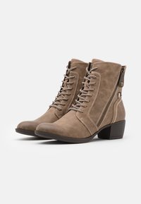 Bottines marron en matériau texturé, dotées de lacets à l'avant, d'une fermeture éclair sur le côté et d'un talon empilé. Accents de couture sur les côtés.