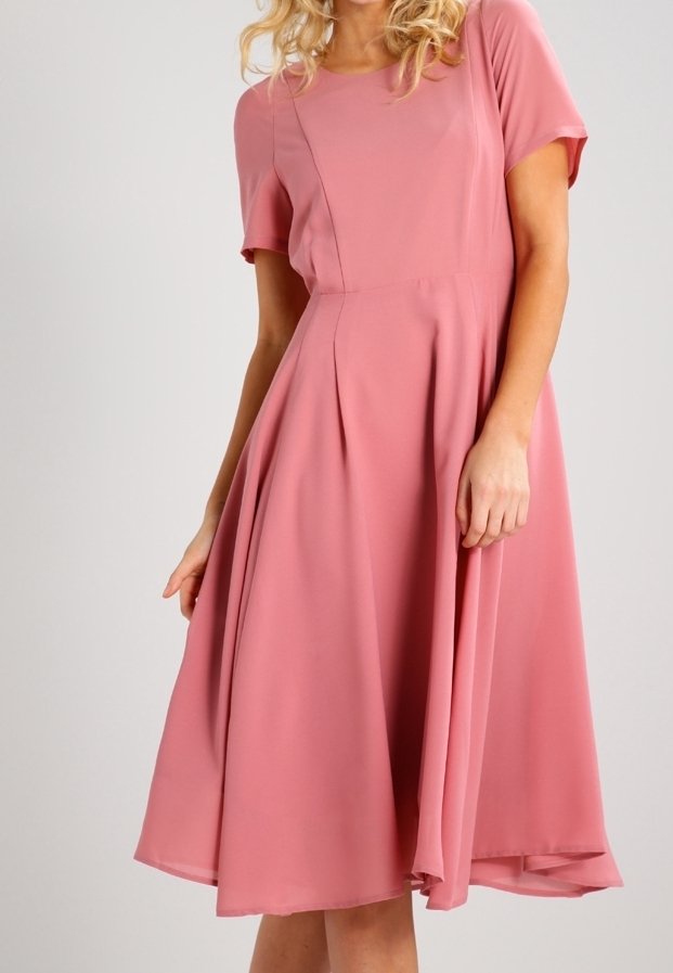 Robe rose à manches courtes en tissu léger avec un corsage ajusté et une jupe évasée ; dotée de plis et d'un col rond.