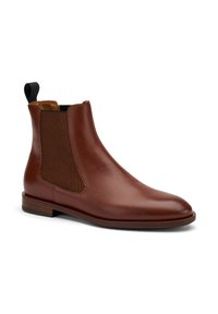 Bota de cuero marrón hasta el tobillo con paneles laterales elásticos, superficie lisa, punta redonda y un tacón bajo de madera. Lengüeta negra en la parte trasera.