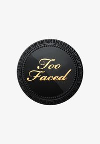 Round black compact with raised decorative edges, featuring the text "Too Faced" in gold lettering on the smooth surface.