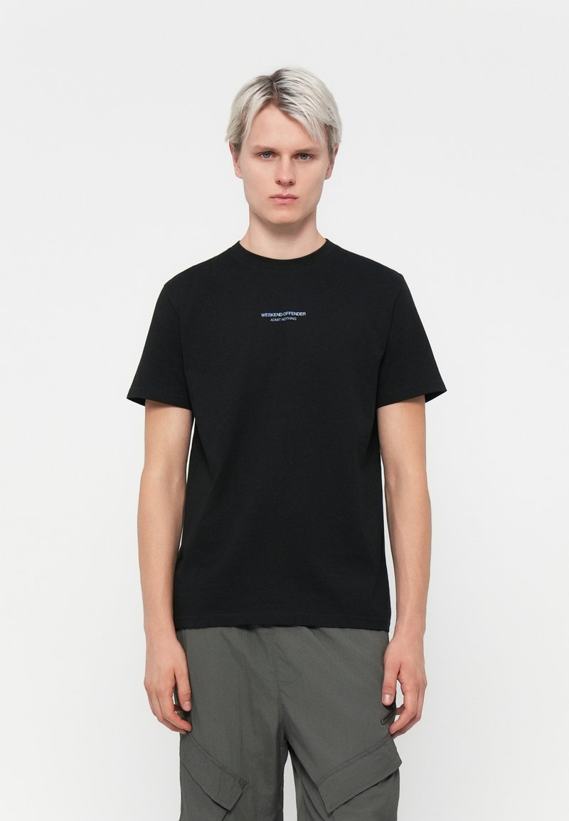 Zwarte katoenen t-shirt met korte mouwen, voorzien van een blauw geborduurd logo op de borst. Eenvoudig, klassiek passend ontwerp.