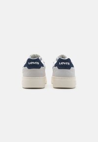 Levi's sneakers har en grå och marinblå mocka-hälen, vit övre del, gräddvit sula och subtila stygndetaljer bak.