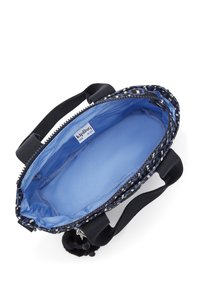 Torebka w czarno-białym wzorze z niebieskim wnętrzem, z zipem, krótkimi uchwytami i wiszącym pomponem jako akcentem.