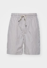 Pantaloni corti bianchi con sottili righe verticali nere, fascia elastica in vita e lacci regolabili davanti.