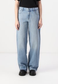Light blue wide-leg jeans made of denim with a relaxed fit, featuring subtle fading, five pockets, and a button-fly closure.