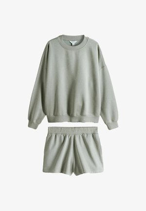 Helehall soe suur lõdvestunud mudeliga pusa pikemate varrukatega, mida on kombineeritud sobivate elastse vöökohaga lühikeste pükstega pehmest ja juhuslikust kangast.