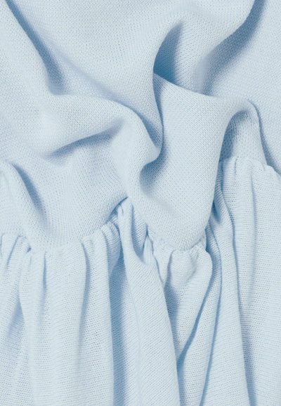 Tessuto lavorato a maglia azzurro chiaro con cucitura elastica arricciata che crea pieghe morbide e superficie testurizzata.
