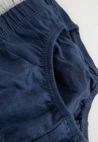 Marineblaue Baumwollslips mit elastischem Bund, weicher Textur und gerafften Nähten um die Beinöffnungen für einen sicheren Sitz.