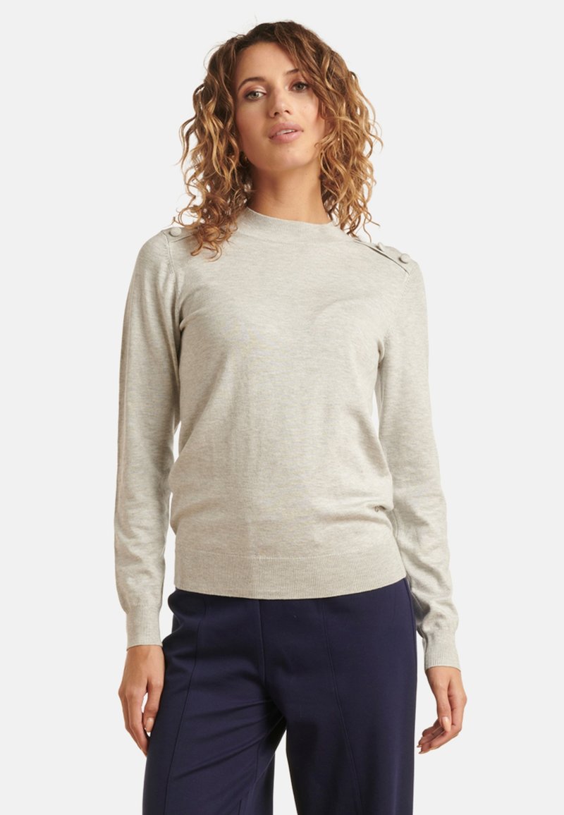 Light gray sweater made of a soft knit material, featuring a high neck, long sleeves, and decorative buttons on the shoulder.