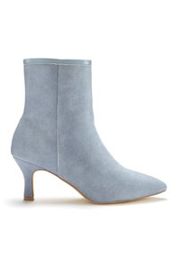 Jasnoniebieski botek za kostkę wykonany z teksturowanej tkaniny, z ostrym noskiem i smukłym, średniej wysokości obcasem. Gładkie akcenty na górnej krawędzi.
