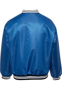 Blauwe satijnen bomberjack met een effen textuur, voorzien van een geribde zwarte en witte gestreepte kraag en manchetten, en een elastische zoom.