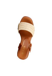 Sandale en cuir marron avec une lanière tressée beige sur les orteils et une bride de cheville ajustable avec boucle.