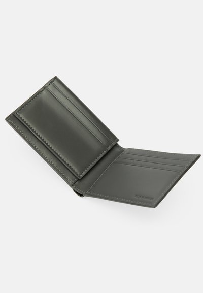 Mørkegrønn skinnlommebok med flere kortspor, en glatt tekstur og pent sting. Åpen design som viser innvendige rom.