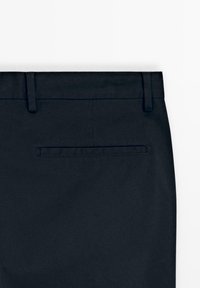 Arrière d'un pantalon bleu marine foncé avec passants de ceinture et une seule poche passepoilée horizontale centrée sous la ceinture.