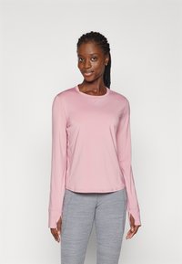 Light pink long-sleeve athletic top with a round neckline and moisture-wicking fabric, paired with gray, textured athletic pants.