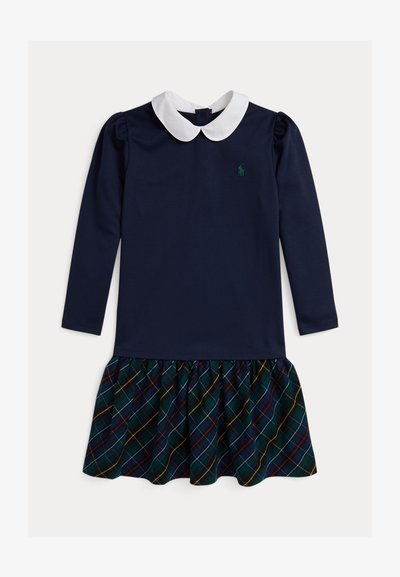 Vestido de manga comprida com parte superior azul-marinho, colarinho branco e saia de padrão xadrez em verde, vermelho e amarelo. Tecido suave com fundo franzido.