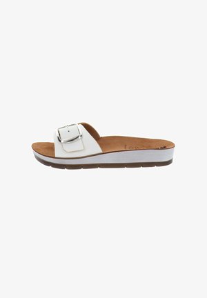 Sandalia tipo slide blanca con una correa ancha, hebilla grande plateada, plantilla acolchada marrón y suela flexible ligeramente elevada.