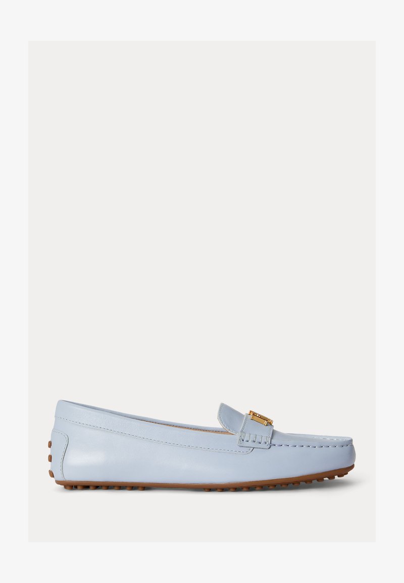 Mocassin en cuir bleu clair avec semelle en caoutchouc marron à picots et petit détail de boucle dorée sur la bride traversant le dessus.