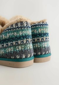 Zapatillas de punto con un patrón multicolor de verdes, azules y grises, con un cuello de piel sintética color beige y una suela de goma color beige.