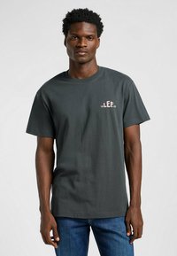 Czarny szary t-shirt z bawełny z małym różowym logo "LEE" na lewej piersi, okrągłym dekoltem i krótkimi rękawami. W połączeniu z dżinsami.