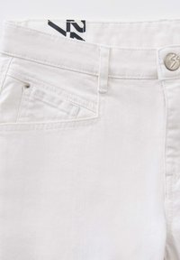 Jeans in denim bianco con chiusura a bottone, tasche frontali angolari e una texture sottile. Etichetta visibile in vita.