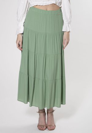 Gonna maxi a balze verde chiaro realizzata in morbido tessuto, caratterizzata da una vita elastica e un design fluido fino alla caviglia.